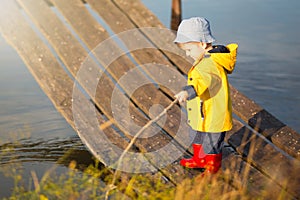 Young little boy fishing from wooden dock