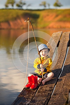 Young little boy fishing from wooden dock