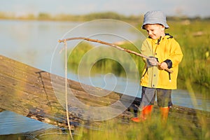 Young little boy fishing from wooden dock