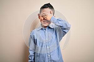 Young little boy kid wearing elegant shirt standing over isolated background very happy and smiling looking far away with hand