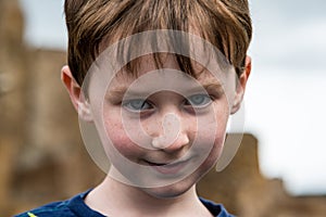 Young little boy portrait looking and smiling at the camera.