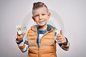 Young little caucasian kid asking for help on a paper note as violence victim message happy with big smile doing ok sign, thumb up