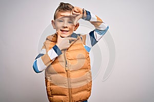 Young little caucasian kid with blue eyes standing wearing winter coat over isolated background smiling making frame with hands