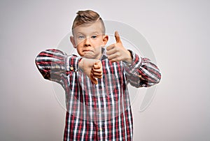 Young little caucasian kid with blue eyes wearing elegant shirt standing over isolated background Doing thumbs up and down,