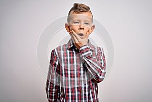 Young little caucasian kid with blue eyes wearing elegant shirt standing over isolated background Looking fascinated with