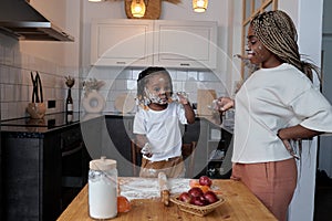 young little chef and his assistent cooking in the kitchen