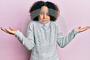 Young little girl with afro hair wearing casual clothes clueless and confused with open arms, no idea and doubtful face