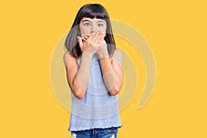 Young little girl with bang wearing casual clothes shocked covering mouth with hands for mistake