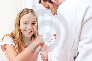 Young little girl being vaccinated at the doctor