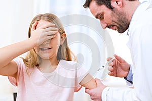 Young little girl being vaccinated at the doctor