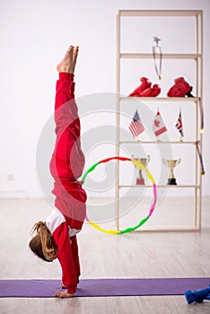 Young little girl doing sport exercises at home