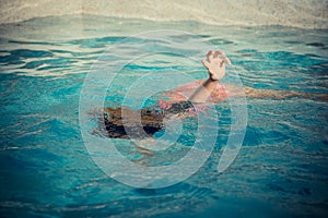 Young little girl floating at swimming pool