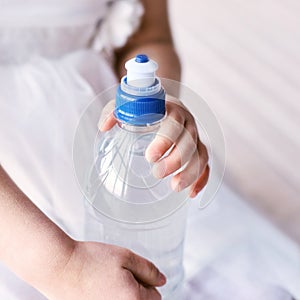 Young little girl hold water bottle. Kid drink cold fresh. Thirsty female person