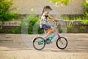 Young little girl learning to ride bike in park