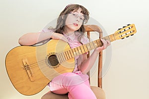 Young little girl playing acoustic guitar