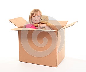 Young little girl sitting inside box