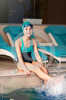 Young little girl swimmer training in a swimming pool