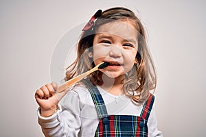 Young little infant girl brushing her teeth using tooth brush and oral paste, cleaning teeth and tongue as healthy health care