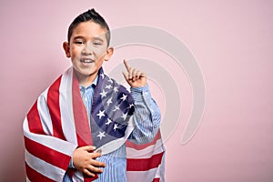 Young little patriotic boy kid covered on united states of america flag on independence day surprised with an idea or question