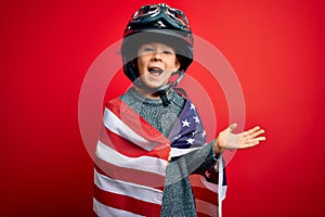 Young little patriotic kid wearing united states of america flag and motorcycle helmet on 4th of July very happy and excited,