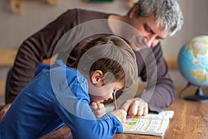 Young little shoolboy solving mathematics homework with father