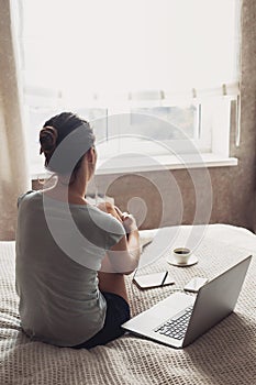 Young lonely girl student using laptop at home. Woman working on computer. Connection, freelance work, work from home