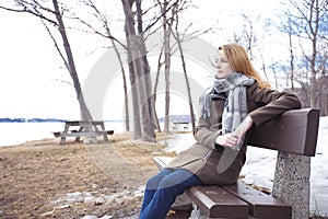 Young lonely woman on bench in park