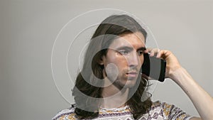 Young long-haired man making a phone call