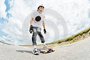 The young Longboarder pushes his foot out on his longboard over the country road