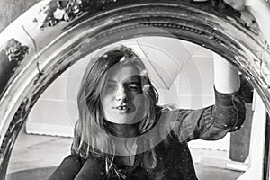 Young longhaired beautiful woman sitting in front of the vintage mirror