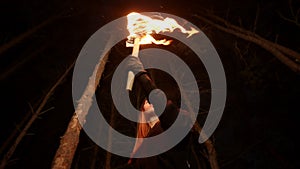 Young lost woman standing in scary winter forest at night with a handmade torch