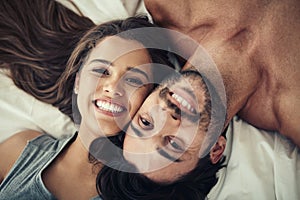 Young and in love. an affectionate young couple relaxing in bed together.