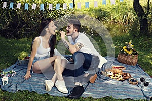 Young love couple have picnic in city park sitting on a blanket