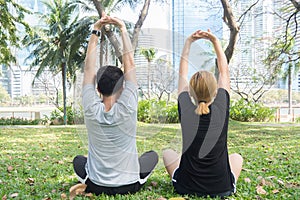 Young love couple making a meditation to calm their mind after exercising in park encircle with a warm light sunshine in afternoon