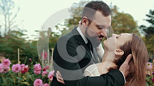 Young in love loving couple hugging. Bride approaches groom, holds him by neck