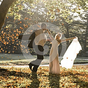 Young in love newly wed couple relaxing in field in golden afternoon sunlight