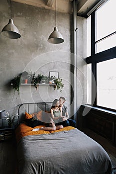 Young lovely couple lying in a bed. Man and woman embracing in bed. Young people deeply in love.  Kissing couple portrait.