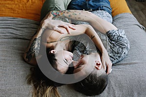 Young lovely couple lying in a bed. Man and woman embracing in bed. Young people deeply in love.  Kissing couple portrait.