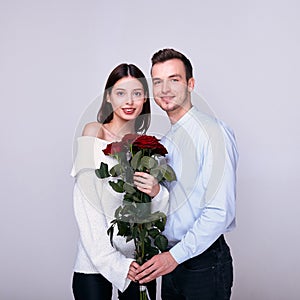 Young lovers with a bouquet of red roses