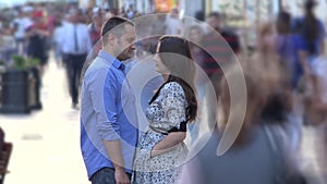 Young lovers couple stand still together in middle of fast moving crowded street, timelapse