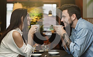Young Lovers Enjoying Coffee Together In Cafe, Side View