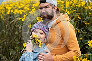 Young lovers hugging and embracing in autumn park with flovers. Couple in love tenderness and affection.