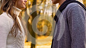 Young lovers looking at each other tenderly, romantic date in autumn forest