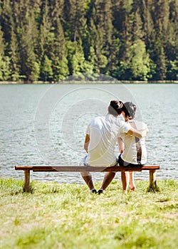 Young lovers sitting on wooden bench