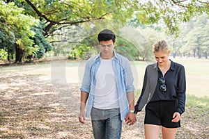 Young lovers walk hand in hand in the park Romanticly. On a relaxing holiday