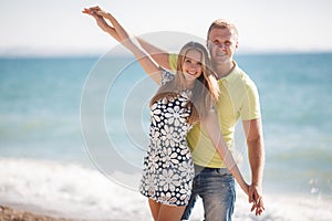 Young loving couple on the beach near the sea