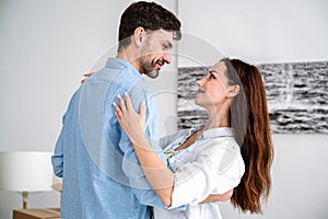 Young loving couple embracing, dancing and looking in eyes each other