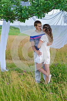 Young loving couple embracing each other under a tree