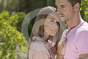 Young loving couple embracing in park