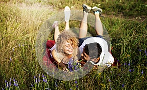 Young loving couple enjoying nature, holding hands and walking on the field with lavender. Beautiful people on nature in spring at